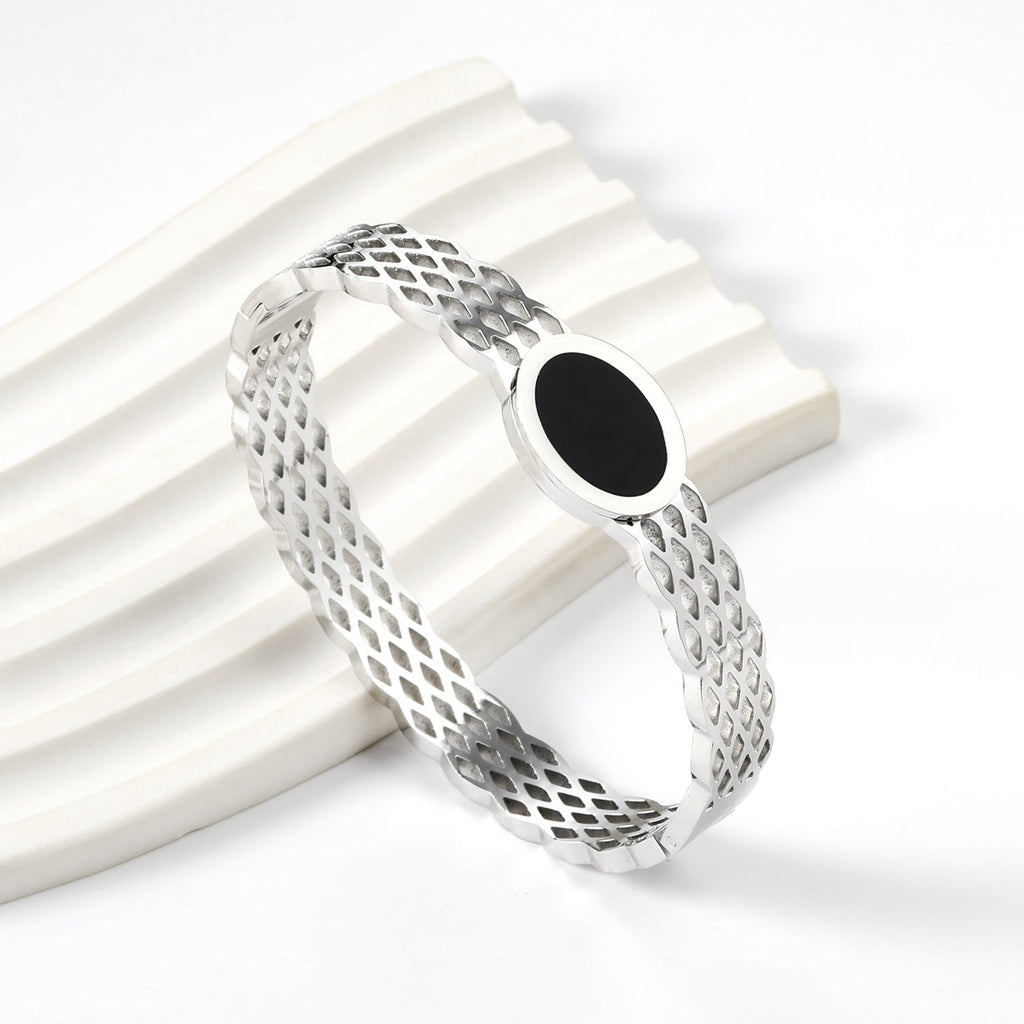 Geweven mesh-armband met zwarte ronde oliedruppels.