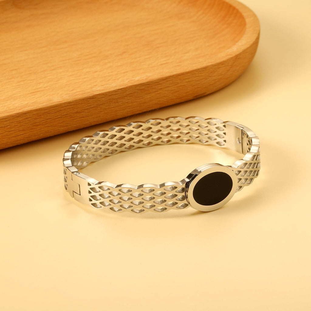 Geweven mesh-armband met zwarte ronde oliedruppels.