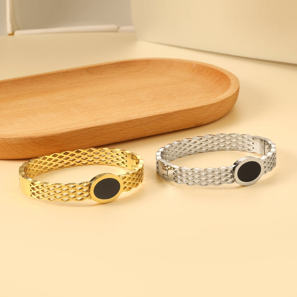 Geweven mesh-armband met zwarte ronde oliedruppels.