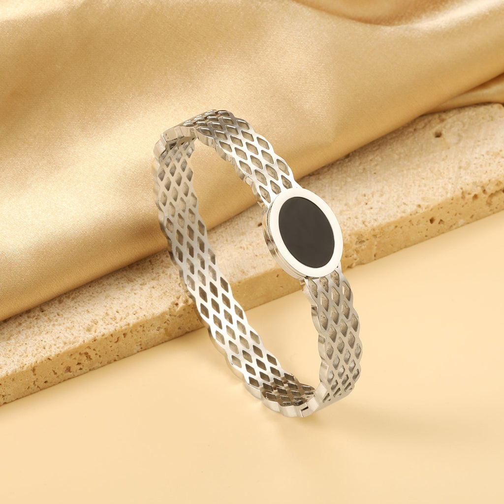 Geweven mesh-armband met zwarte ronde oliedruppels.
