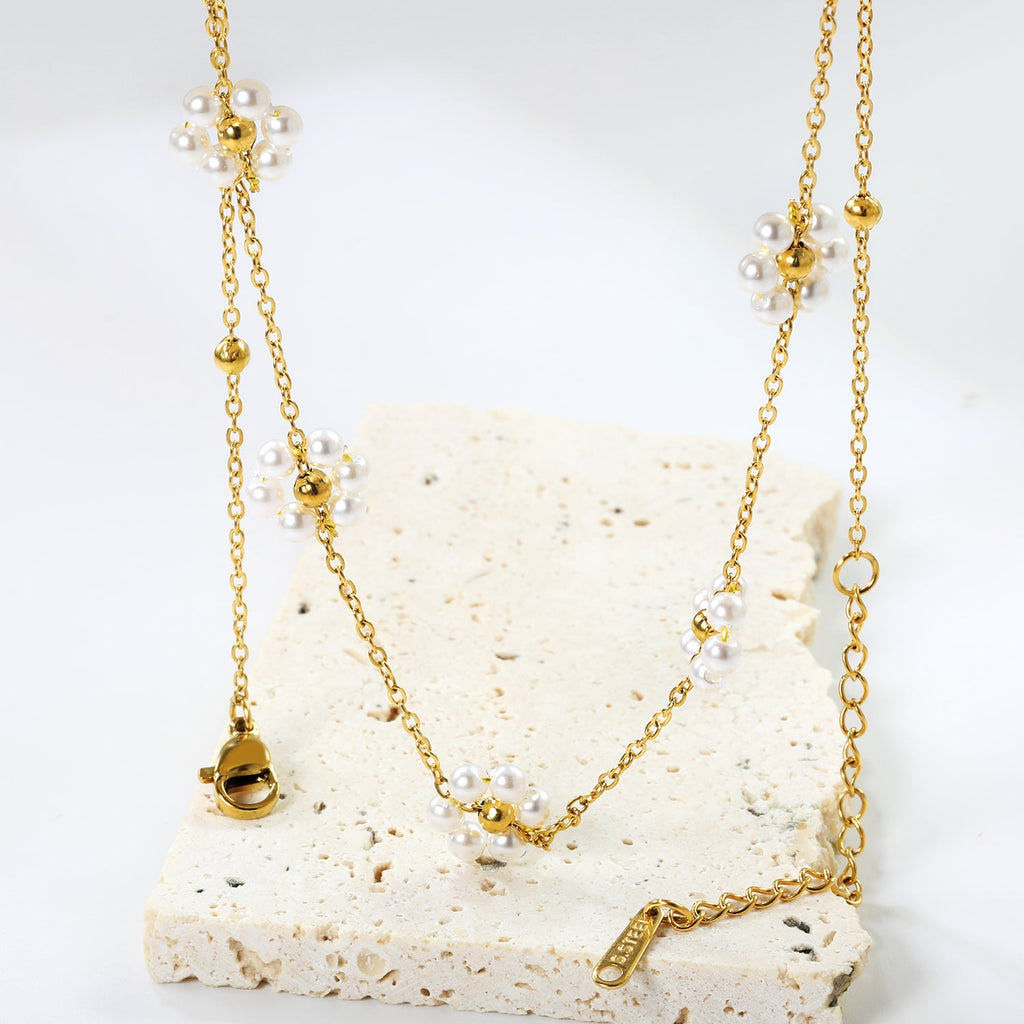 Ketting met stalen kralen en parelbloemhanger