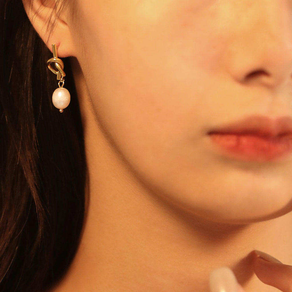 Touwknoop met witte parels oorbellen