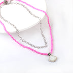 Dubbele ketting met schelpen en roze kralen