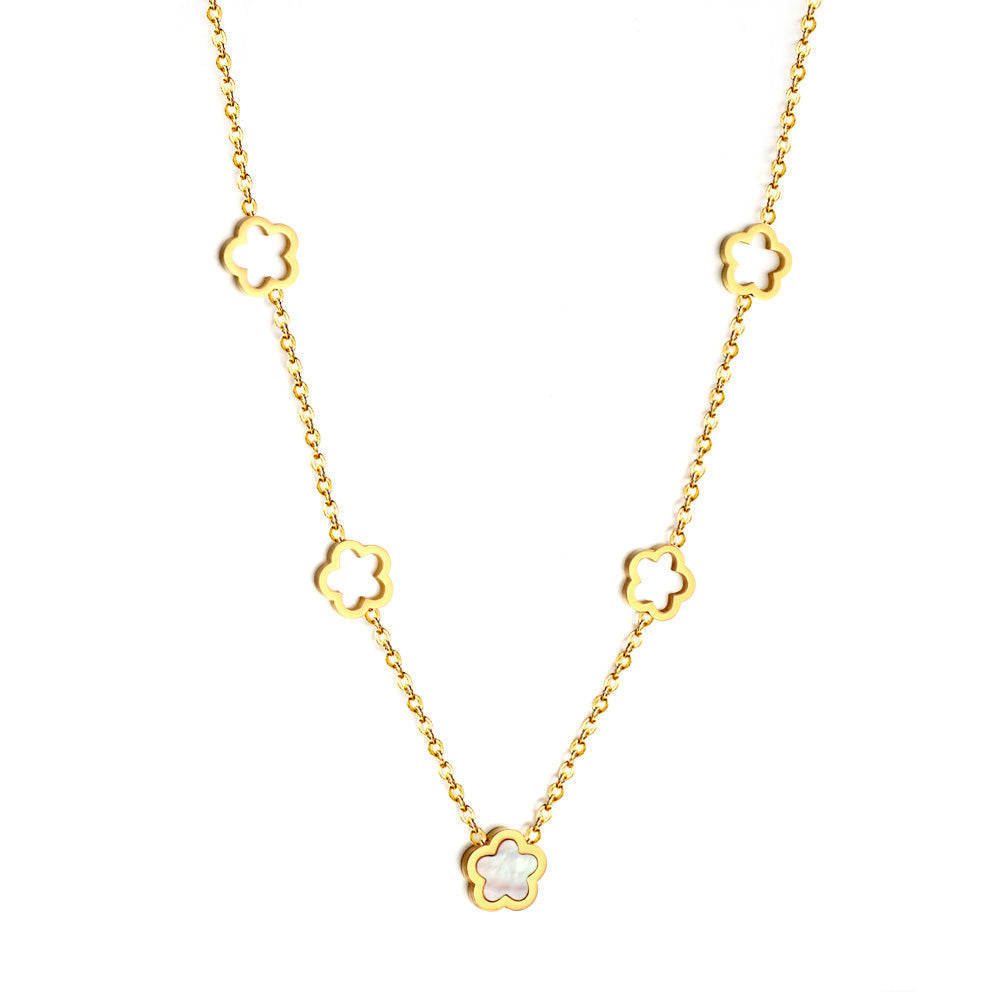 Peach Blossom Necklace by The JCS Jewelry — gold PVD-coated stainless steel chain featuring four hollow blossoms and one white shell charm, hypoallergenic and tarnish-resistant.